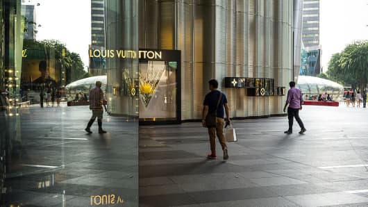 A shopper walks past a Louis Vuitton store in the Ion Orchard mall on Orchard Road in Singapore.