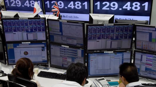 Traders ckeck computer screens showing the Japanese yen rate against the British pound at a brokerage in Tokyo on October 7, 2016.