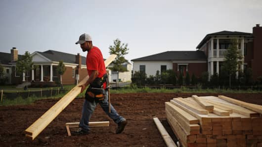 A contractor moves lumber for a house under construction in the Norton Commons subdivision of Louisville, Kentucky.