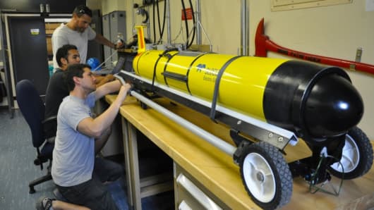David Barney (foreground), Eric Sanchez and Daniel Braun, Systems Center Pacific engineers at Space and Naval Warfare Systems Command, perform pre-deployment inspections on littoral battlespace sensing gliders aboard the Military Sealift Command oceanographic survey ship USNS Pathfinder.