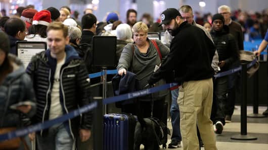 Travelers wait in line at O'Hare International Airport on December 23, 2016.