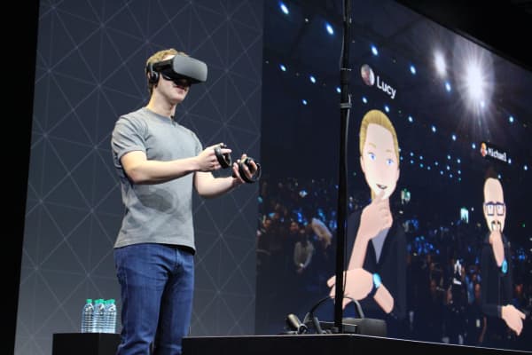 Facebook co-founder and chief executive, Mark Zuckerberg, speaks at an Oculus developers conference while wearing a virtual reality headset in San Jose, California