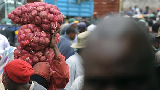 A Kenyan man carries a bag of onions at the Marikiti market in Nairobi