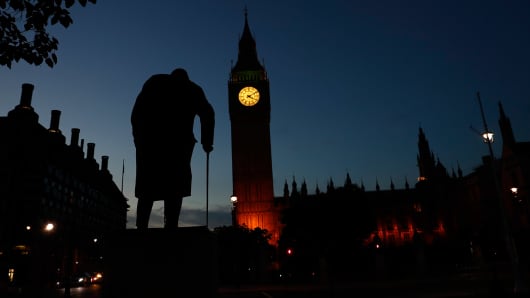 Dawn breaks behind the Houses of Parliament and the statue of Winston Churchill in Westminster, London, Britain June 24, 2016.