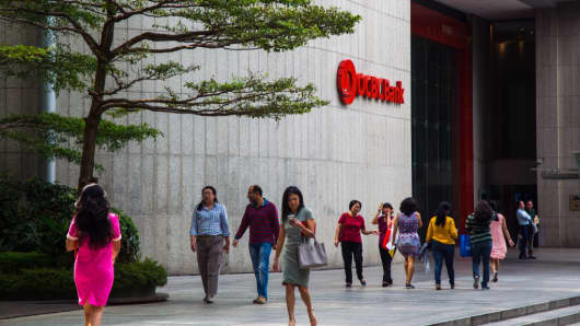 Pedestrians walk past an OCBC branch in the central business district of Singapore, on Friday, Feb. 10, 2017.
