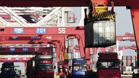 En esta foto tomada el miércoles 4 de enero de 2012, un contenedor se carga en un camión, a la derecha, en un puerto en Qingdao, en la provincia de Shandong, este de China.  El comercio de China sufrió su mayor declive desde la crisis de 2008 en enero, un nuevo signo de débil demanda mundial y una desaceleración de la economía nacional.  Las exportaciones cayeron un 0,5 por ciento respecto al año anterior a $ 149.9 mil millones, mientras que las importaciones bajaron un 15 por ciento a $ 122.7 mil millones, según los datos de aduanas del viernes 10 de febrero de 2012. (Foto AP) CHINA OUT