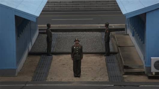 In this photo taken on Monday, April 23, 2012, North Korean soldiers stand guard on the demarcation line of the Demilitarized Zone that separates the two halves of the Korean peninsula at Panmunjom, North Korea. (AP Photo/Vincent Yu)