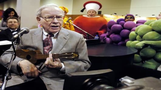 Berkshire Hathaway chairman Warren Buffett plays the ukelele at the Fruit of the Loom stand at the Qwest Center in Omaha, Neb., while touring exhibits prior to the annual Berkshire Hathaway shareholders meeting, Saturday, April 30, 2005. (AP Photo/Nati Harnik)