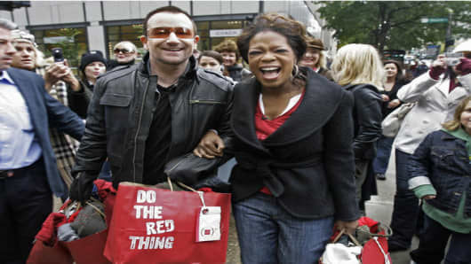 Irish rocker Bono, frontman for U2, and talk show host Oprah Winfrey walk down Chicago's "Magnificent Mile" Thursday, Oct. 12, 2006, for a shopping spree to promote Bono's new RED line of clothing, accessories and gadgets that will raise money to fight AIDS in Africa. (AP Photo/M. Spencer Green)