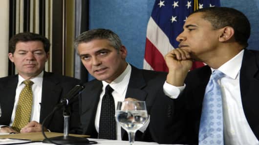 Academy Award winning actor George Clooney, center, flanked by Sen. Barack Obama, D-Ill., right, and  Sen. Sam Brownback, R-Kan., takes part in a news conference at the National Press Club in Washington, Thursday, April 27, 2006 to bring awareness to the situation in the Darfur region of Sudan. (AP Photo/Mannie Garcia)