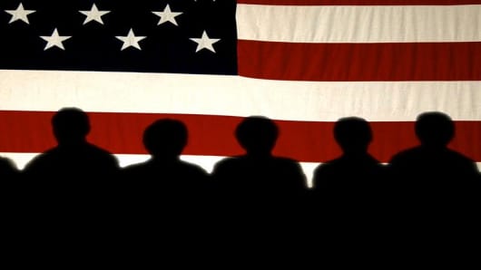 Supporters are silhouetted on a flag as they listen to Vice President Dick Cheney speak at a town hall meeting, Tuesday, Sept. 28, 2004 in Dubuque, Iowa. (AP Photo/Charlie Neibergall)