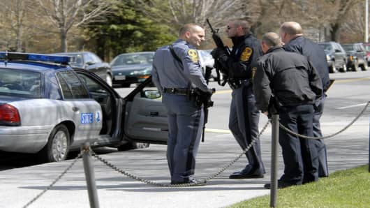 State and local police wait for a building to be cleared by police on the Virginia Tech campus in Blacksburg, Va., Monday, April 16, 2007, following a shooting incident. Police said the shootings have left at least 20 people dead and a similar number injured. (AP Photo/Don Petersen)