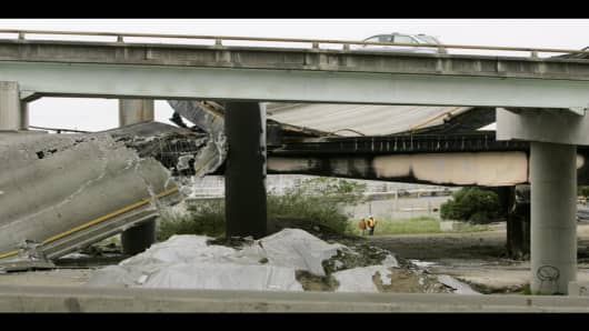 CalTrans workers investigate a crumbled section of freeway ramp which connects Interstate 80 to Interstate 580 in Oakland, Calif., after a tanker carrying gasoline exploded on Sunday, April 29, 2007. In the resulting blaze, a section of freeway that funnels traffic onto the San Francisco-Oakland Bay Bridge collapsed. The truck's driver walked away from the scene and called a taxi, which took him to a nearby hospital with second-degree burns. (AP Photo/Ben Margot)