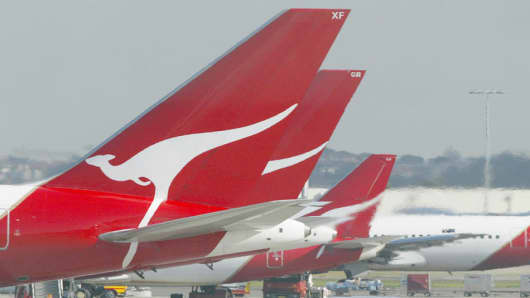 Qantas passenger jets parked at their terminal at Sydney Airport.