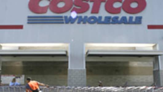 A Costco employee pulls shopping charts at a Costco Wholesale store.