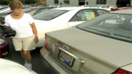 Woman looks at new Toyota Camry on dealer lot