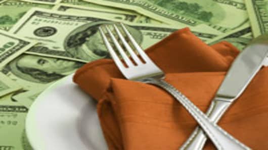 Fork and knife, place setting on money, cutlery on napkin with plate, expensive food