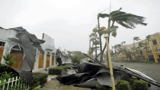 Parts of a roof lie on the sidewalk as trees sway in the winds of Hurricane Wilma Monday, Oct. 24, 2005 in downtown Naples, Fla. Hurricane Wilma crashed ashore early Monday as a strong Category 3 storm, battering southwest Florida with 125 mph winds. (AP Photo/Wilfredo Lee)