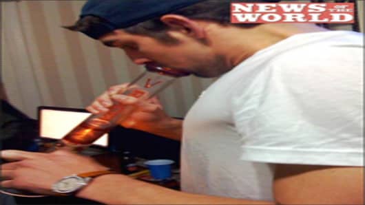 Michael Phelps inhales from a bong