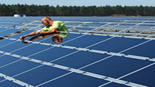 A worker installs solar panels at the Lieberose Solar Park in Lieberose, Germany.