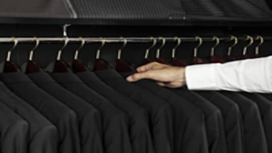 Man selecting a jacket from a clothing rack