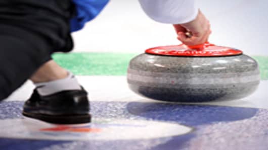 A competitor releases his stone during the men's curling round robin game between Germany and the United States at the Vancouver 2010 Winter Olympics.