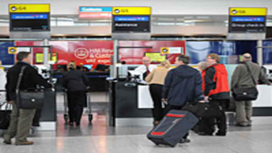 Passengers are pictured at Check-In desks at London's Heathrow airport.
