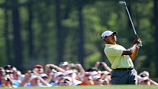 Tiger Woods hits a shot as fans look on during a practice round prior to the 2010 Masters Tournament at Augusta National Golf Club.