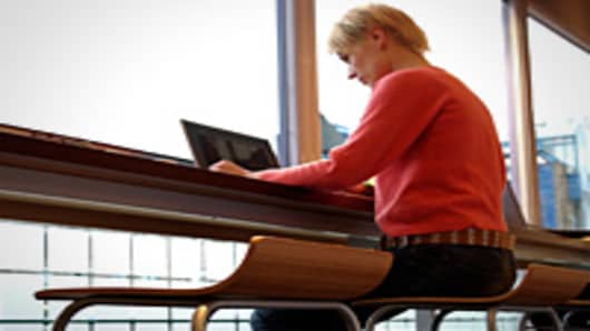 Woman using laptop in internet cafe