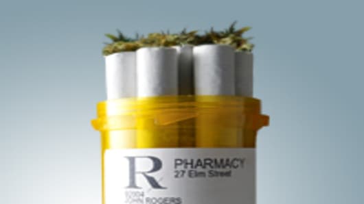 A pharmaceutical pill bottle with marijuana cigarettes coming out of the top.