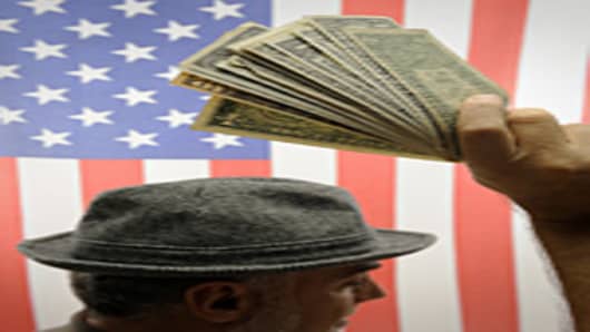 Man's hand raised with US dollars over US flag
