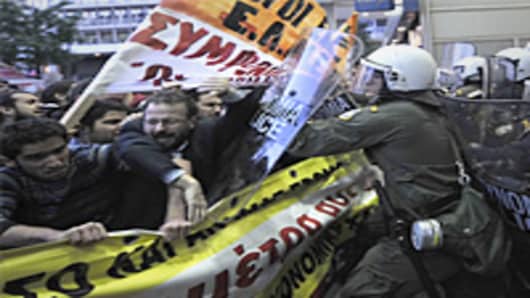 Riot policemen push back demonstrators as they try to approach the finance ministry in Athens.