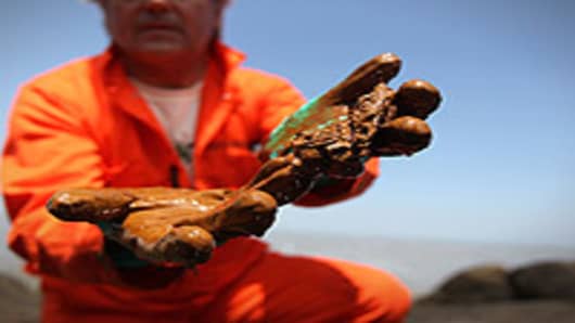 Greenpeace marine biologist Paul Horsman shows oil collected from a jetti at the mouth of the Mississippi River near Venice, Louisiana. BP announced today that it is successfully siphoning off 1,000 barrels of oil per day from the Deepwater Horizon oil rig that exploded and sank to the bottom of the Gulf of Mexico.