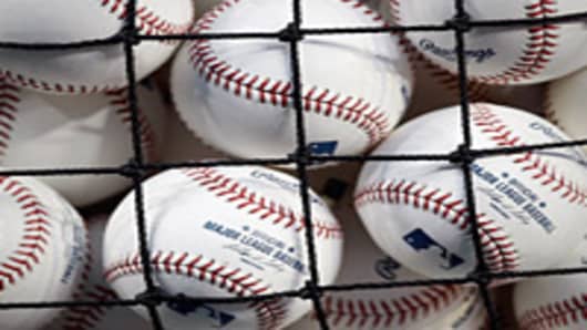 MLB baseballs seen through the netting of a basket