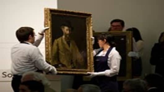 Sotheby's staff carry away the Edouard Manet painting entitled 'Portrait De Manet Par Lui-Meme, en Buste' (Manet A La Palette) ('Self-Portrait with a Palette') after it was auctioned at Sotheby's in London on June 22, 2010 where it fetched 20,000,000GBP.