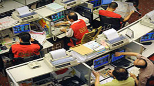 Traders sit at their desks at the Stock Exchange in Hong Kong.