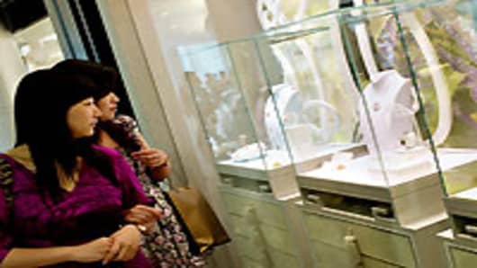 Two women look at a jewelry display in a luxury shopping mall in Shanghai. Following in the footsteps of Japan, China has become the world's second-largest consumer of high-end fashion, accessories and luxury goods.