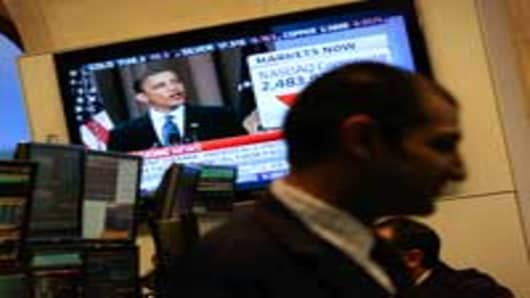 Financial professionals work on the floor of the New York Stock Exchange at midday as President Obama gives a speech about Wall Street financial reform.