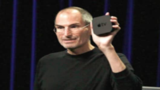 Apple CEO Steve Jobs holds the new, smaller Apple TV device as speaks during an Apple Special Event in San Francisco.