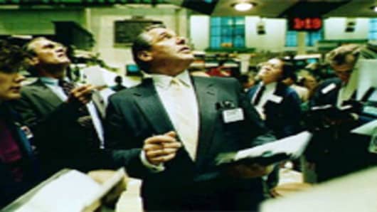 Traders on the floor of the New York Stock Exchange floor watch monitors on October 10, 1987.