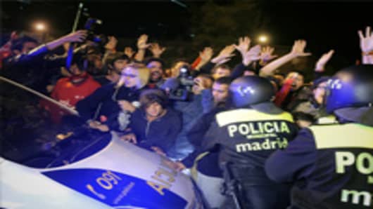 Demonstrators block a police car on the parking lot of the Madrid transport bus company during the general strike held in whole Spain in Madrid as unions launched a 24-hour general strike all around Spain to protest tough government labor reforms and austerity measures.