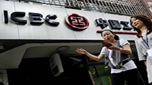 Pedestrians walk past a branch of the Industrial and Commercial Bank of China (ICBC) in Shanghai.