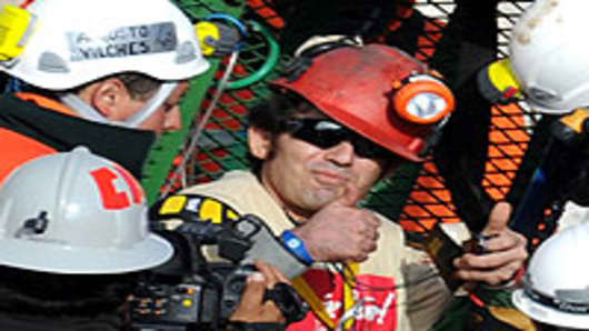Chilean miner Alex Vega Salazar gives a thumbs up upon exiting the Fenix capsule as the tenth miner to be brought to the surface, on October 13, 2010.