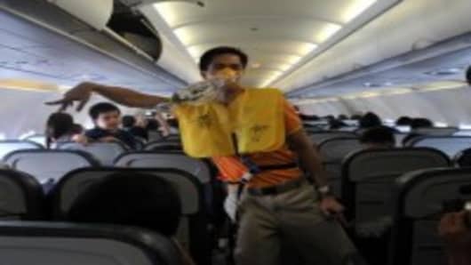 A cabin crew member of budget airline Cebu Pacific performs a dance as part of the inflight safety demonstration during a flight between Manila and Davao City