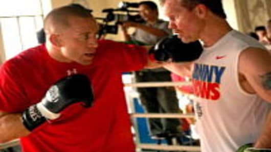 UFC welterweight champion Georges St-Pierre (L) of Canada spars with Philippine boxing star Manny Pacquaio's trainor Freddie Roach during a visit to Pacquaio's training at a gym in Manila on September 24, 2010.