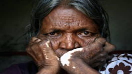Woman who is suffering from extreme poverty sits in her home in Andrha Pradesh, India August 19, 2005.
