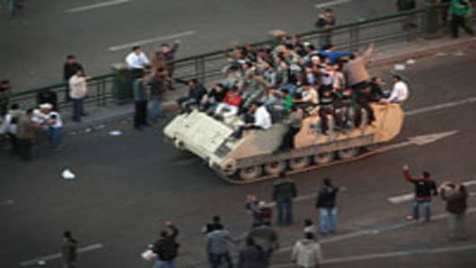 Protestors ride an armoured personnel carrier towards the Nile on January 29, 2011 in Cairo, Egypt. Tens of thousands of demonstrators have taken to the streets across Egypt in Cairo, Suez, and Alexandria to call for the resignation of President Hosni Mubarak.