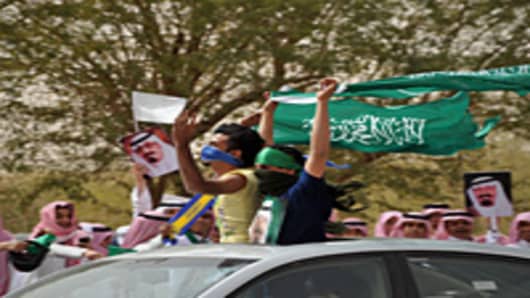 Saudi youth wave their national flag as they celebrate the return of King Abdullah bin Abdul Aziz in the Saudi capital Riyadh.