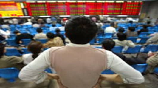 A local investor watches the share-prices index display at a stock brokerage in Shanghai.