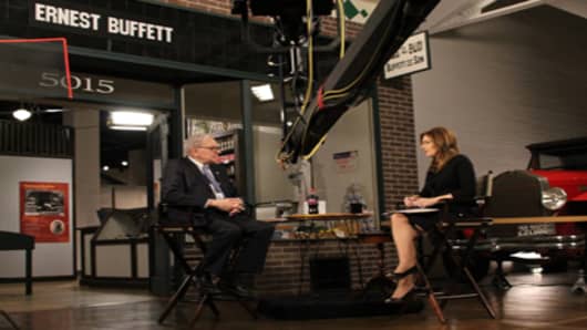 Warren Buffett is interviewed by CNBC's Becky Quick in 2011 in front of a mock-up of the Buffett family grocery store in Omaha where he worked as a child.